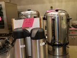 un plan de travail en acier inoxydable sur lequel sont posées deux cafetières et une machine à café