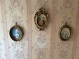 three framed pictures on the wall above a toilet