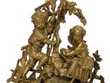 bronze figurine of a boy and a girl sitting on a rock