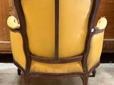 a yellow chair sitting in front of a wooden cabinet