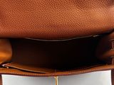the inside of a brown leather purse with a gold clasp
