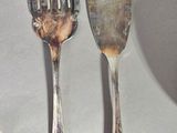 three silver spoons and a fork on a table