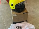 un casque jaune posé sur une boîte en carton, sur un sol carrelé