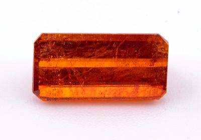 un gros plan d'une pierre de couleur orange sur une surface blanche