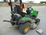 a green tractor that is parked on the side of the road