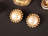 three pairs of gold and pearl earrings on a black surface