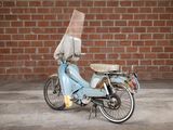 a scooter that is parked in front of a brick wall