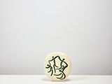 an image of a button with a drawing on it sitting on a table