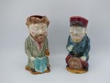pair of ceramic figurines of a man and a woman sitting on a stool
