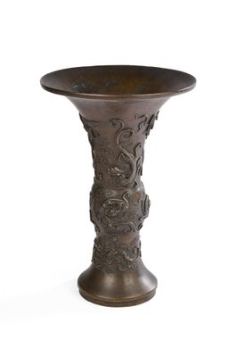 un vase en bronze posé sur une surface blanche