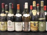 many bottles of wine that are lined up on a table