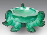 une image représentant un bol en verre vert orné d'une tortue
