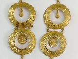two pairs of gold tone earrings with a circular design and tassels