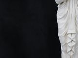 statue of a woman in a white dress holding a flower