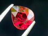 un gros plan d'un diamant rouge tenu par une pince