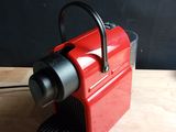 a red machine that is sitting on a wooden table
