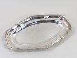 une assiette ancienne en argent posée sur un fond blanc