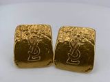a pair of gold earrings with the letter y on them
