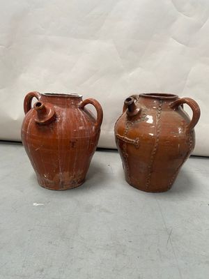 two brown vases sitting next to each other on a table