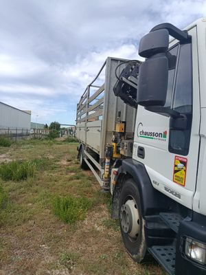a truck that is parked in the grass near a building