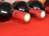 several bottles of wine are lined up on a red table