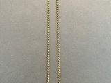 a gold necklace with a long chain hanging from it ' s end