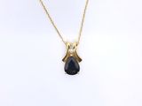 a gold necklace with a black tear shaped stone on a gold chain