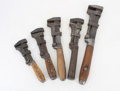 five old tools are lined up in a row on a white surface