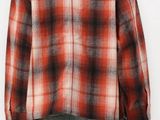 the back view of a man wearing a red and black plaid shirt