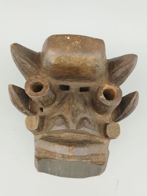 une image représentant un masque en bois sur un fond blanc