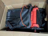 a box with a black bag and a red and black bag in it