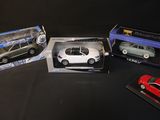 four different models of cars are in boxes on a black surface