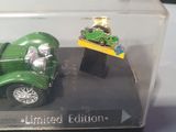 a green toy car and a green toy car in a display case