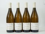 four bottles of wine are lined up on a white surface