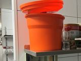 un pot orange posé sur une étagère dans une cuisine