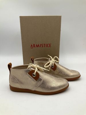 une paire de chaussures métalliques avec une boîte en arrière-plan
