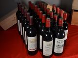 many bottles of wine sitting on a red table cloth