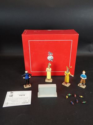 figurines représentant des personnes debout devant une boîte rouge posée sur une surface noire