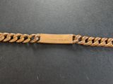 gros plan d'un bracelet en or sur une surface noire