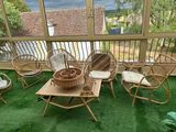 une photo d'une terrasse avec des chaises en osier et une table