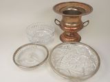 three glass dishes and a silver vase on a table