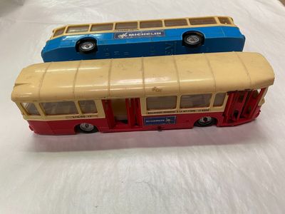 deux petits bus posés sur une surface blanche