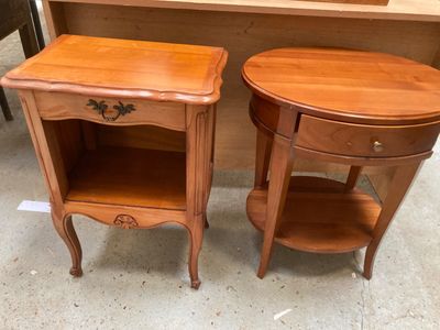 une paire de tables d'appoint en bois avec des tiroirs et des étagères dans une pièce