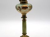 une lampe ancienne en laiton et en verre vert sur fond blanc