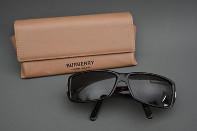 Lunettes de soleil Burberry noires avec étui, sur fond gris