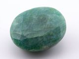 an image of a green stone on a white surface