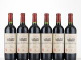 six bouteilles de vin rouge alignées sur une table