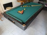 une table de billard sur laquelle se trouvent une boule de billard et des queues