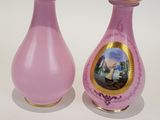 two pink vases with pictures on them sitting on a table