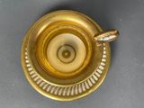 a gold cup and saucer on a gray table